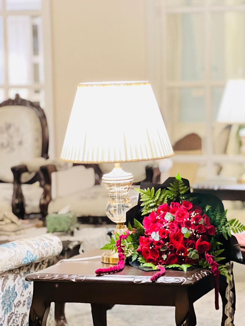 Lavish scarlet rose bouquet with hanging amaranthus on antique mahogany table in Ooty